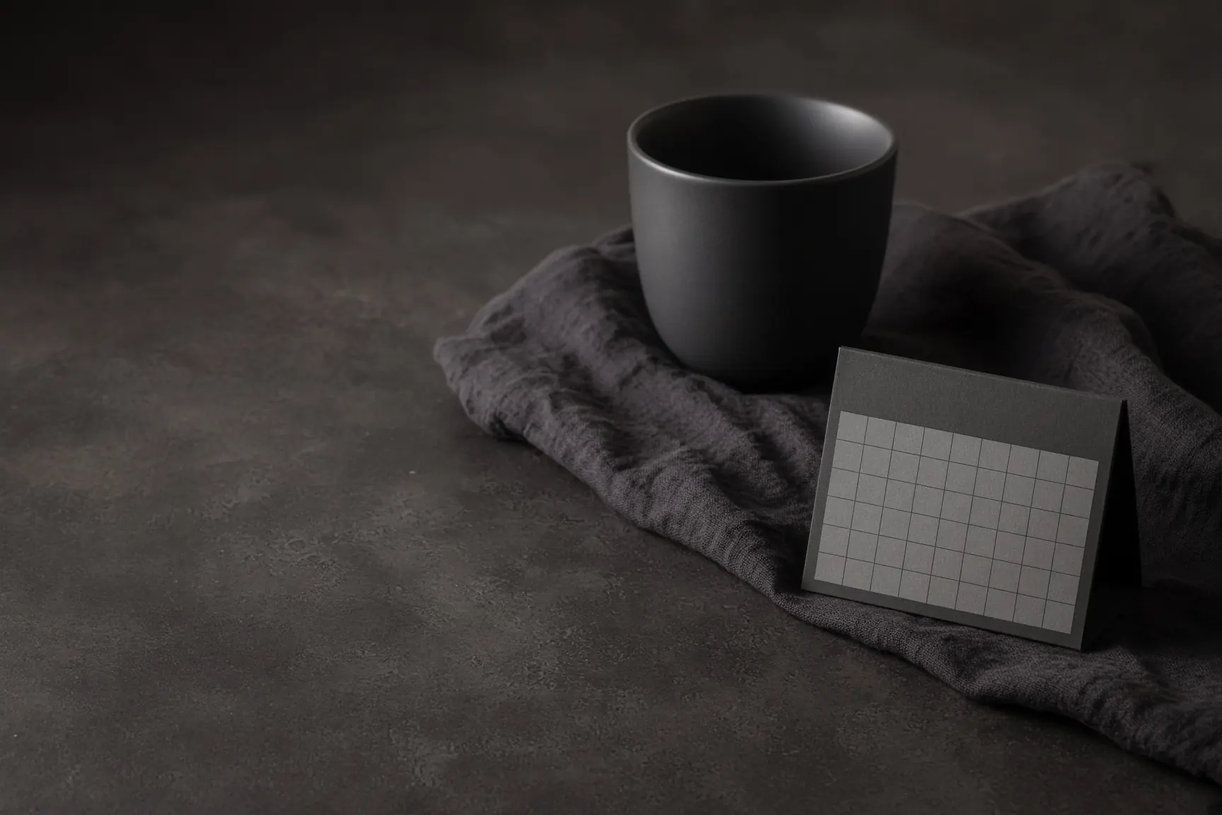 Dark linen and a matte black cup, private and calm