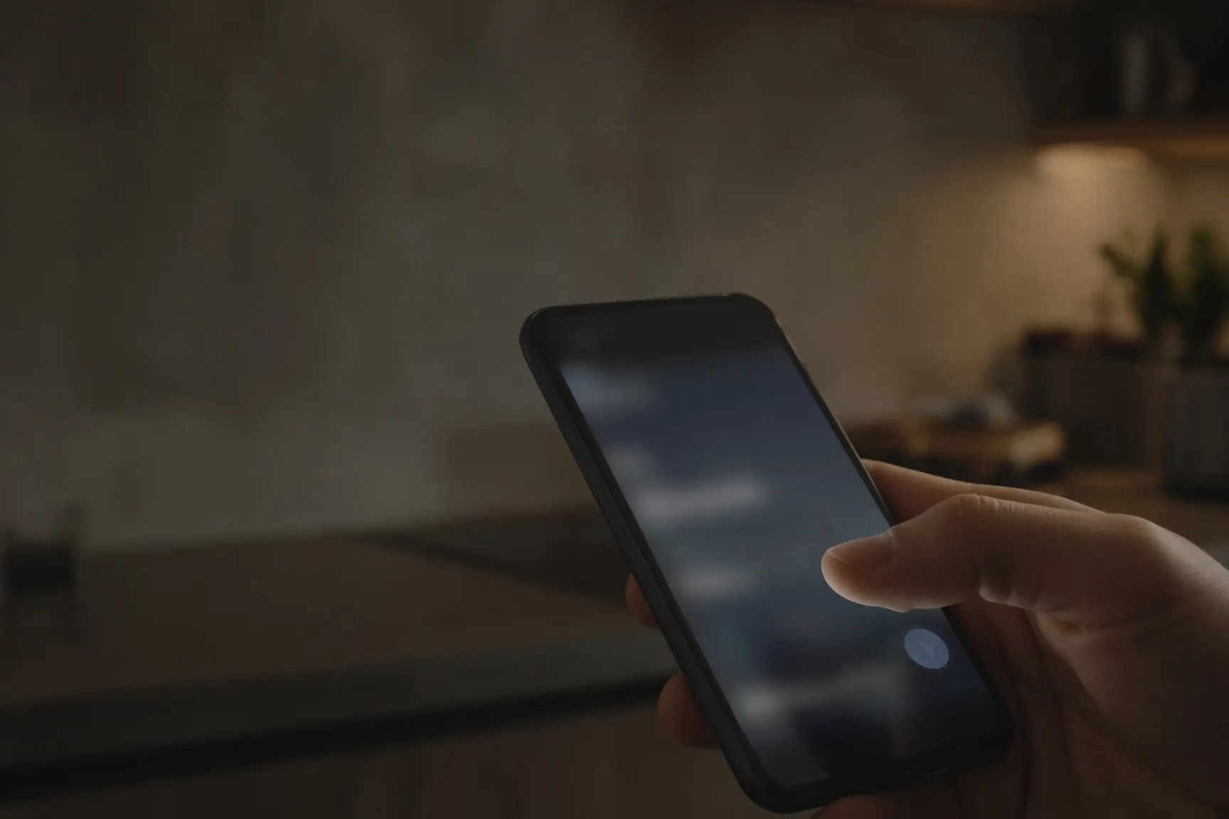 A thumb hovering over send, late kitchen light