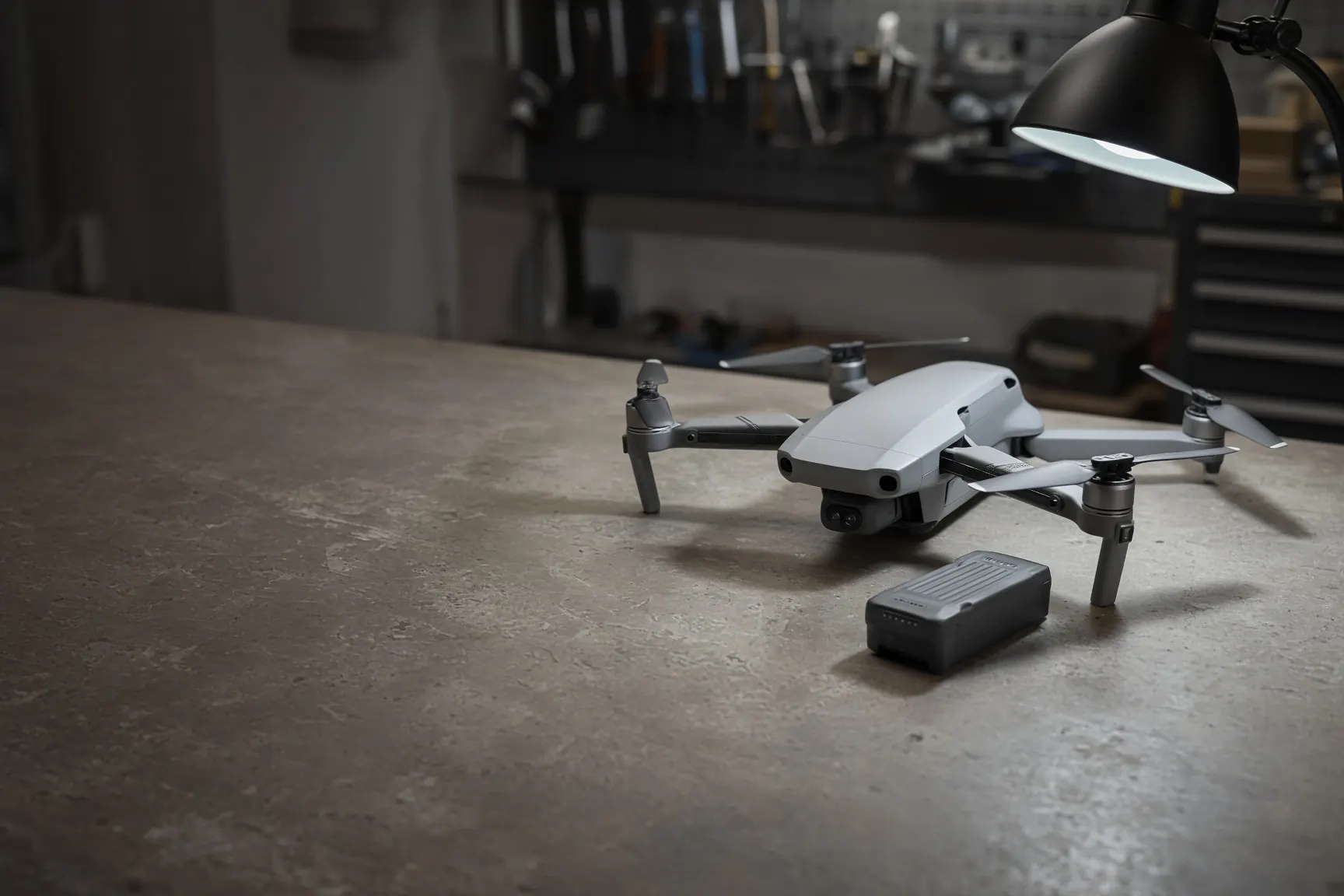 Quadcopter and a spare battery on a workbench